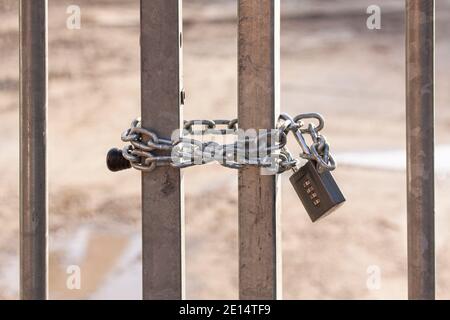 Stahlbarschor mit starker Kette und Vorhängeschloss Stahlbarschtor mit starker Kette und Vorhängeschloss, um den Eintritt in einen eingeschränkten Bereich zu verhindern. Stockfoto