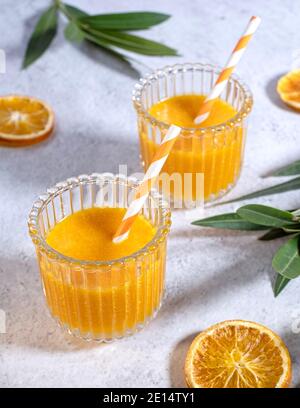 Frisch zubereitetes Orangensaft, wunderschön in zwei Gläsern auf einem Marmortisch angeordnet, Draufsicht, Portrait, Stockfoto