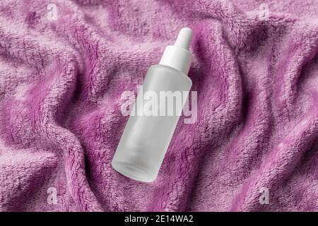 Serum mit Kollagen und Peptiden Cosy Flat Lay auf rosa Plüsch fuzzy Stoff. Hyaluronsäure Tinktur, Mockup. Home Beauty Behandlung Konzept Stockfoto
