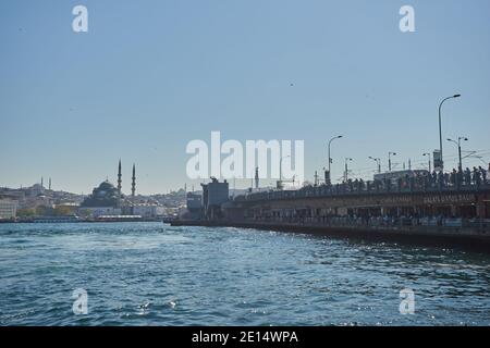 Istanbul, Türkei - 22. April 2018: Galata Brücke mit traditionellen Fischrestaurants in der Passage unter der Brücke mit Blick auf Galata Turm in der Ferne Stockfoto