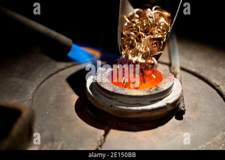 Stücke von Gold in metallurgischen Ofen mit Feuer für geladen Schmelzen Stockfoto