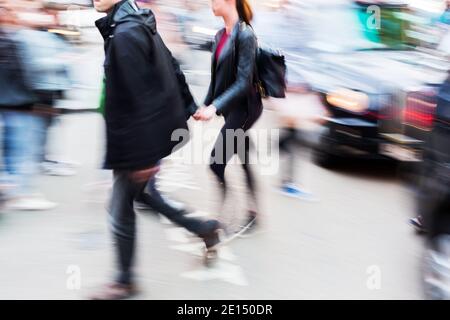 Bild mit Kamera gemacht Bewegungsunschärfe-Effekt eines Paares Überqueren einer Stadtstraße Stockfoto