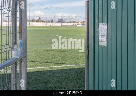 Campos, Spanien; januar 03 2020: Handspender für alkoholisches Gel am Eingang des Fußballfeldes in der Stadt Campos. Im Hintergrund der SoC Stockfoto