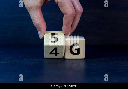 Zeit bis 5G. Männliche Hand dreht einen Holzwürfel und ändert Zeichen 4G auf 5G. Technologie, Business, Netzwerk, Kommunikation und 5g-Konzept. Wunderschönes Dunkelgrau Stockfoto