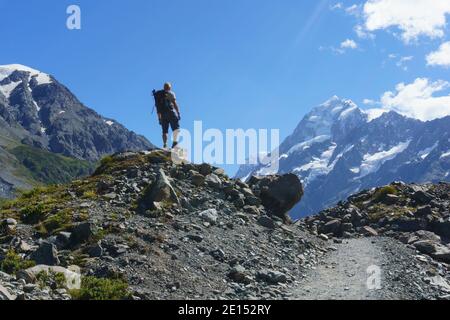 Mount Cook Neuseeland - Februar 16 2015; Lone Hiker steht auf einem Steinhaufen neben dem Hookers Valley Track und blickt auf Mount Cook Stockfoto