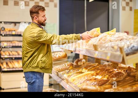 Männlich Auswahl frisches Brot im Laden, Blick auf Sortiment im Lebensmittelgeschäft Stockfoto