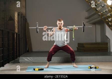 Körperlich stark behinderter armenloser Mann trainiert in der Turnhalle. Tackling Langhantel Stockfoto