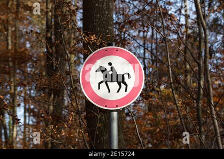 Dießen, Deutschland - 8. November 2020: Schild 'Reiten verboten'. Im Herbst in einem bayerischen Wald gefangen. Bäume im Hintergrund. Stockfoto