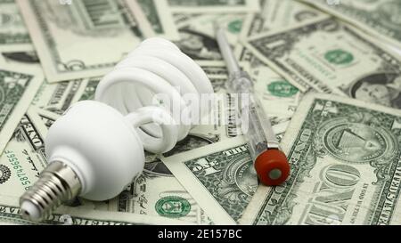 Energiesparlampe und US Dollar Papiergeld Stockfoto