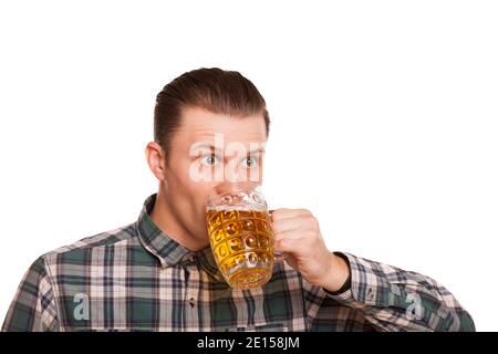 Junger Mann trinkt Bier isoliert auf weiß. Attraktiver Mann, der überwältigt aussieht, während er im Studio ein köstliches Bier aus dem Glas trinkt. Feiern, trinken Stockfoto