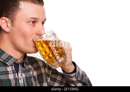 Nahaufnahme eines jungen gutaussehenden Mannes, der Bier isoliert auf Weiß trinkt. Attraktiver Mann schlürft Bier freudig aus dem Glas, CO Stockfoto