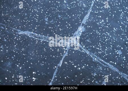 Risse im Eis auf einem gefrorenen Teich - Nahaufnahme, Eisstruktur Stockfoto