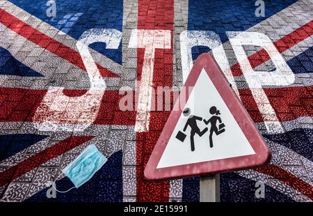 Zurück zur Schule Covid 19, Coronavirus Konzept. Schild in der Nähe der Schule mit Gesichtsmaske, Stop und Flagge von Großbritannien überlagert. Stockfoto