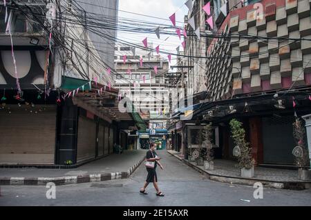 Eine Frau trägt eine Maske als vorbeugende Maßnahme gegen die Ausbreitung von covid-19 Spaziergänge an geschlossenen Nachtclubs entlang Patpong Street.Thailand Regierung ordnete die Schließung von Bars und andere Unterhaltungseinrichtungen und mehrere andere überfüllte Veranstaltungsorte in Bangkok ab 1. Januar 2020 bis 28. Januar 2020 inmitten einer neuen Welle des Coronavirus-Ausbruchs in Thailand. Stockfoto