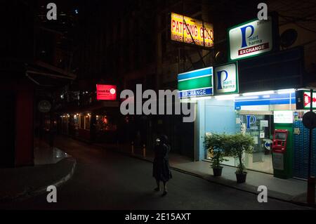 Eine Frau, die an den Geldwechselplätzen entlang der Patpong Street vorbeiläuft.die thailändische Regierung ordnete die Schließung von Bars und anderen Unterhaltungseinrichtungen und mehreren anderen überfüllten Veranstaltungsorten in Bangkok vom 1. Januar 2020 bis zum 28. Januar 2020 inmitten einer neuen Welle des Coronavirus-Ausbruchs in Thailand an. Stockfoto