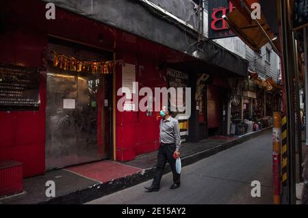 Ein Mann mit einer Maske als vorbeugende Maßnahme gegen die Ausbreitung von covid-19 geht vorbei an einem geschlossenen Nachtclub in Patpong Street.Thailand Regierung ordnete die Schließung von Bars und andere Unterhaltungseinrichtungen und mehrere andere überfüllte Veranstaltungsorte in Bangkok ab 1. Januar 2020 bis 28. Januar 2020 inmitten einer Neue Welle des Coronavirus-Ausbruchs in Thailand. Stockfoto