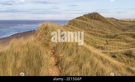 Formby Sanddünen vor der Blackpool Strandpromenade (links im Hintergrund) und der Marina Brücke bei Southport (rechts im Hintergrund). Stockfoto