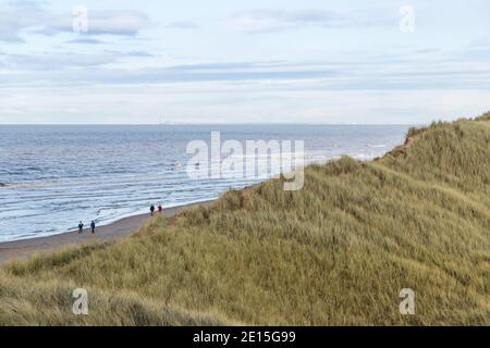 Mit Blick auf die mit Gras bewachsenen Sanddünen von Marram am Strand von Formby mit Blick auf Blackpool. Stockfoto