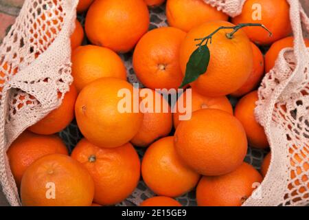 Nahaufnahme eines wiederverwendbaren Saitenbeutels mit einer Menge Frisch gepflückte Orangen Stockfoto