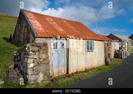 South Harris, Isle of Lewis und Harris, Schottland: Bunte alte Schuppen mit einer blauen Tür Stockfoto