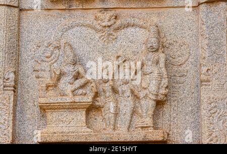 Hampi, Karnataka, Indien - 4. November 2013: Hazara Rama Tempel. Nahaufnahme der beigefarbenen Stein beschädigt Skulptur an der Wand mit Gruppe von Royals. Stockfoto