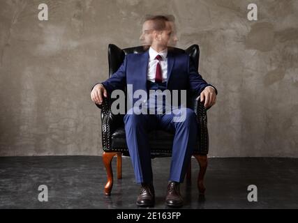 Geschäftsmann mit geteilter Persönlichkeit sitzt im Sessel Stockfoto