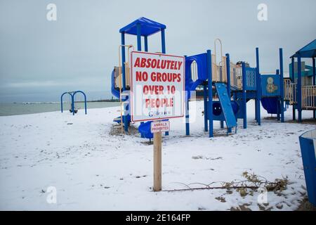 Am Strand, in der Nähe des Spielplatzes, heißt es auf der Beschilderung: Absolut keine Gruppen über 10 Personen. Stockfoto