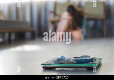 Konzept der nicht in Gewichtsverlust, Schuppen im Vordergrund und frustriert frustriert Frau im Hintergrund. Stockfoto