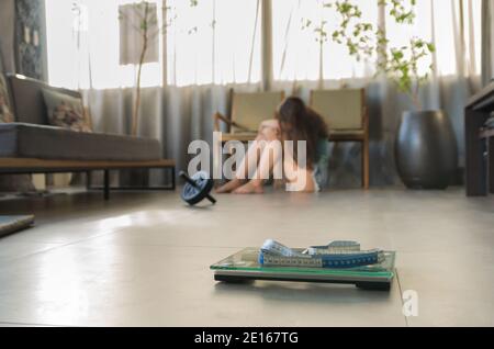 Konzept der nicht in Gewichtsverlust, Schuppen im Vordergrund und frustriert frustriert Frau im Hintergrund. Stockfoto