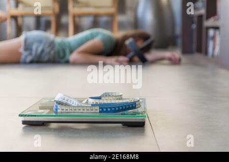 Konzept der nicht in Gewichtsverlust, Schuppen im Vordergrund und frustriert frustriert Frau im Hintergrund. Stockfoto