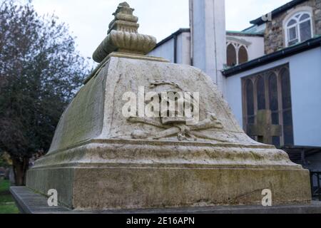 Schädel und Kreuzknochen auf einem Grabstein in einem geschnitzt kirchenfriedhof Stockfoto