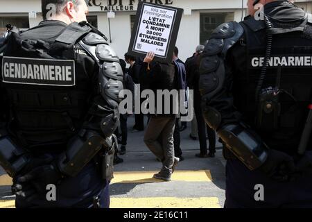 Non-Profit-Organisationen, die sich der Bekämpfung von HIV/AIDS-Hilfe widmen, und Act up-Aktivisten, die von französischen Anti-Riot-Polizisten umgeben sind, demonstrieren am 3. Mai 2011 vor dem französischen Senat in Paris. Gegen einen Gesetzesentwurf zu protestieren, der die Fähigkeit für schwer erkrankte Immigranten, vor allen Ausweisungsmaßes geschützt und im Rahmen des Aufenthaltsrechts für medizinische Versorgung stabilisiert zu werden, ändern wird. Die Plakate lauteten: "Strafe zum Tod von 28.000 kranken Einwanderern". Foto von Stephane Lemouton/ABACAPRESS.COM Stockfoto