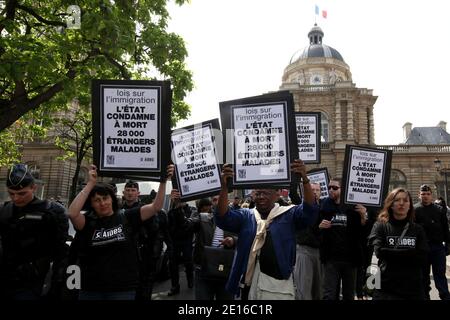 Non-Profit-Organisationen, die sich der Bekämpfung von HIV/AIDS-Hilfe widmen, und Act up-Aktivisten, die von französischen Anti-Riot-Polizisten umgeben sind, demonstrieren am 3. Mai 2011 vor dem französischen Senat in Paris. Gegen einen Gesetzesentwurf zu protestieren, der die Fähigkeit für schwer erkrankte Immigranten, vor allen Ausweisungsmaßes geschützt und im Rahmen des Aufenthaltsrechts für medizinische Versorgung stabilisiert zu werden, ändern wird. Die Plakate lauteten: "Strafe zum Tod von 28.000 kranken Einwanderern". Foto von Stephane Lemouton/ABACAPRESS.COM Stockfoto