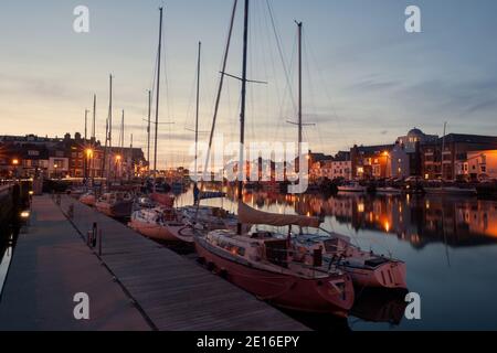 WEYMOUTH, DORSET, UK - 15. MÄRZ 2009: Blick auf den Alten Hafen bei Nacht mit Booten, die am Kai festgemacht sind Stockfoto