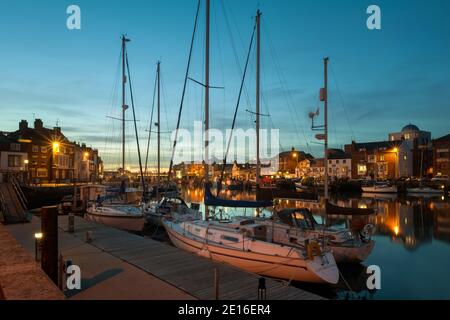 WEYMOUTH, DORSET, UK - 15. MÄRZ 2009: Blick auf den Alten Hafen bei Nacht mit Booten, die am Kai festgemacht sind Stockfoto