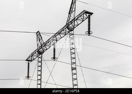 Hochspannungs-Poldetail isoliert am wolkigen Himmel. Stockfoto