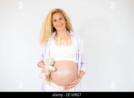 Junge schöne schwangere Frau auf weißem Hintergrund stehen. Stockfoto