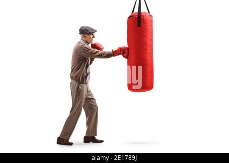 In voller Länge Profilaufnahme eines älteren Mannes, der einen Schlag Tasche mit roten Boxhandschuhen isoliert auf weißem Hintergrund Stockfoto