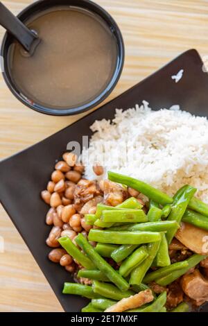 Draufsicht Fast Food Entenfleisch mit Schweinefleisch und Erdnüssen Und Bohnen mit Reis und Brei vertikale Zusammensetzung Stockfoto