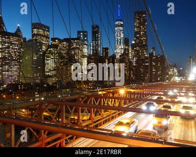 Autoverkehr auf der Brooklyn Bridge mit Bürotürmen an der Wall Street Und One World Trade Center Stockfoto