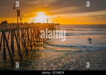 Pismo Beach, California, USA - 1. Januar 2021 Pier, der sich in Richtung der untergehenden Sonne erstreckt, Panorama. Ein ikonischer kalifornischer Holzpier bei 1, 370 Fuß Lo Stockfoto