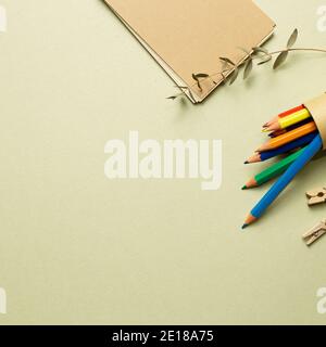 Notizblock und Farbstifte auf khaki Hintergrund. Flach legen, Draufsicht, Kopierraum Stockfoto