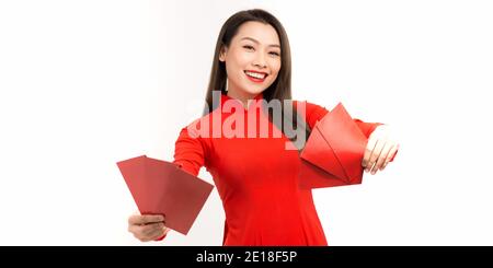 Asiatische Mädchen in traditionellen und nehmen roten Umschläge Mondneujahr, Konzept feiert Lunar Neujahr oder tet Festival, isoliert auf weißem Hintergrund. Stockfoto