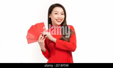 Asiatische Mädchen in traditionellen und nehmen roten Umschläge Mondneujahr, Konzept feiert Lunar Neujahr oder tet Festival, isoliert auf weißem Hintergrund. Stockfoto