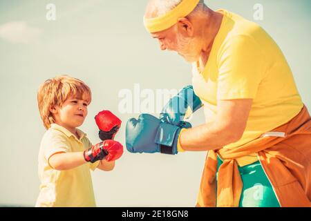 Kleiner Junge Sportler beim Boxtraining mit Trainer. Vater trainiert seinen Sohn beim Boxen Stockfoto