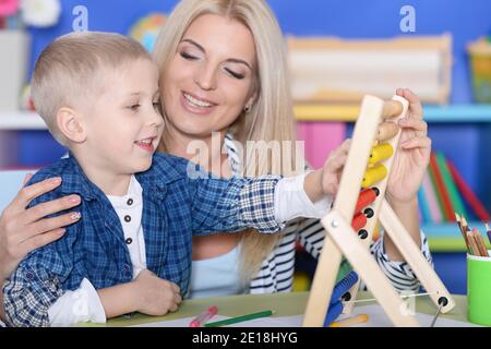 Junge Mutter und niedlichen kleinen Sohn mit Abakus Stockfoto