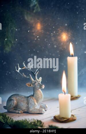 Sylvester Silberhirsch und brennende Kerzen. Silvester, Weihnachten, Winter Komposition Stockfoto