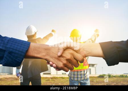 Geschäftsleute schütteln die Hände und Techniker halten Hand Erfolgsprojekt Werkseitige Hintergrund Stockfoto