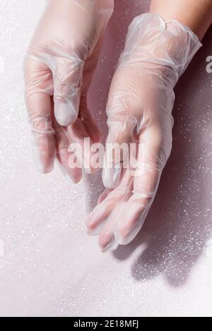 Frau Hände tragen transparente Einweg-Kunststoff-Handschuh auf weißem Hintergrund Stockfoto