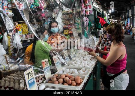 Manila, Philippinen. Januar 2021. Anbieter tragen Masken neigen dazu, Kunden auf einem Markt in Manila, den Philippinen, 5. Januar 2021. Die Inflation auf den Philippinen stieg im Vergleich zum Vorjahr im Dezember 2020 auf 3.5 Prozent, ein Anstieg von 3.3 Prozent im November 2020, getrieben von einem Anstieg der Nahrungsmittel und alkoholfreien Getränke, teilte die Philippine Statistics Authority (PSA) am Dienstag mit. PSA-Chef Dennis Mapa sagte einer virtuellen Pressekonferenz, dass dies die höchste Inflation seit März 2019 sei. Quelle: Rouelle Umali/Xinhua/Alamy Live News Stockfoto